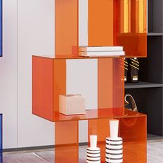 an orange and white shelf in a room with bookshelves, vases and other items