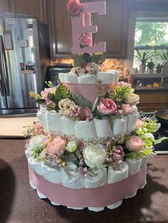 a tiered cake decorated with flowers and diapers