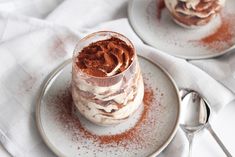 two desserts with chocolate frosting and powdered sugar on them sitting on plates