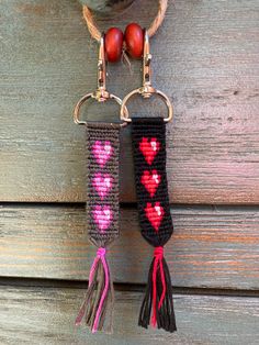 two key chains with hearts and tassels attached to them