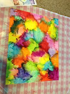 the paper has been made to look like colorful leaves and is on top of a pink checkered tablecloth