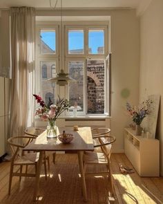 a dining room table and chairs in front of a window