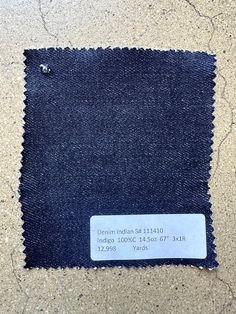 the back side of a pair of dark blue jeans with a white tag on it