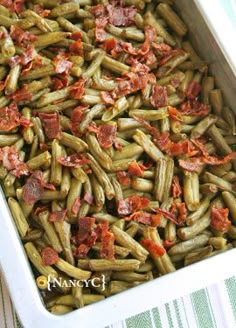 a white dish filled with green beans and bacon