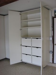 an empty closet with white drawers and shelves