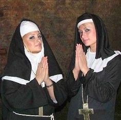 two women dressed in nun costumes applauding each other with their hands clasped together