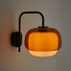 a wall light that is on the side of a wall with a lamp attached to it