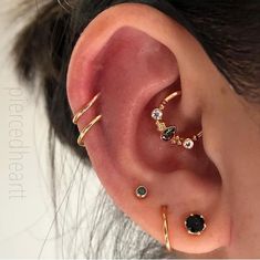 an ear with three different types of piercings on top of it, and one in the middle