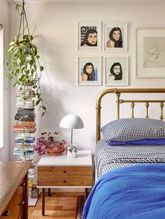 a bed room with a neatly made bed and pictures on the wall