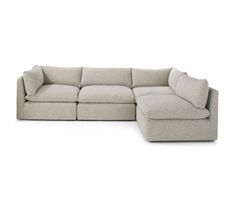 a large sectional couch with pillows on the top and bottom, sitting in front of a white