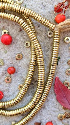 some gold colored metal beads and red leaves