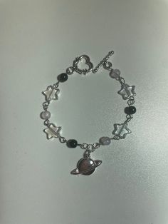 This adorable starry Saturn bracelet has the perfect charm and character for any look. The stars compliment the Saturn middle piece perfectly. This bracelet is 6 inches long. Message us privately if a larger or smaller size is required. Follow us for more shop updates!  https://www.instagram.com/blackrosegardenco/ https://www.tiktok.com/@blackrosegardenco?lang=en https://pl.pinterest.com/blackrosegardenco/ Metal Charm Bracelet With Star Charm, Trendy Star Charm Bracelet, Trendy Metal Charm Bracelet With Star Charm, Silver Star Bracelets For Everyday, Trendy Silver Star Bracelet, Star-shaped Metal Bracelets As Gifts, Trendy Silver Star Charm Bracelet, Cute Silver Dangle Charm Bracelet, Handmade Silver Star Bracelets