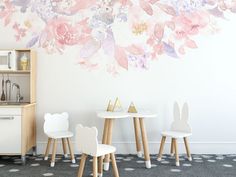 the wall is decorated with pink flowers and white chairs