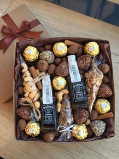 a box filled with assorted chocolates and nuts on top of a wooden table