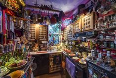 a kitchen filled with lots of clutter and cooking utensils