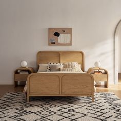 a bedroom with a bed, nightstands and rug on the floor in front of it