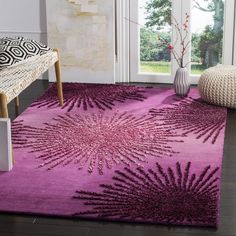 a purple rug with an intricate design on the floor in front of a large window