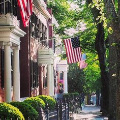 an american flag is hanging on the side of a row of houses