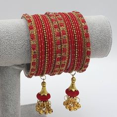 A stacks of antique gold stone bangles with latkan drop. Beautiful Designer antique gold plated and 22 Metal Bangles Set . Match them with your favorite color Bangles or wear them their own. The set comes in twelve colors Bangles.  Two sizes available: 2.10 Festive Metal Bracelets With Latkans, Festive Metal Bracelet With Latkans, Adjustable Temple Jewelry Bangle For Celebrations, Bohemian Gold Bangle With Latkans, Gold Bohemian Bangle With Latkans, Gold Bohemian Bangle For Puja, Metal Bangle For Festivals And Celebrations, Metal Bangle For Celebrations And Festivals, Metal Bangle For Celebration And Festivals