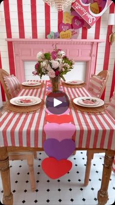 the table is decorated with pink and red striped cloths, heart cutouts, and plates