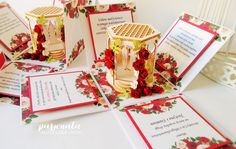 many cards and envelopes with red flowers on them are sitting on a table next to each other