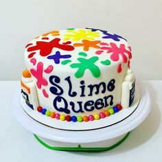 a white cake with multicolored frosting that says slime queen on it