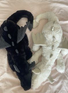 two stuffed animals laying next to each other on a bed