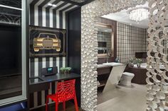 the bathroom is decorated in black and white stripes with gold accents on the walls, along with a red chair