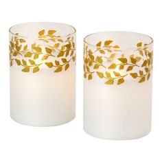 two white candles with gold leaves on them