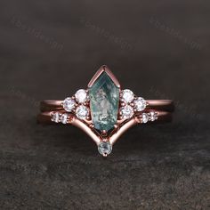 a close up view of a ring with an aqua green stone and white diamonds on it