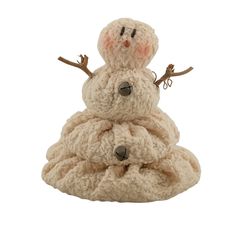 a stuffed snowman sitting in the middle of a pile of blankets on top of each other