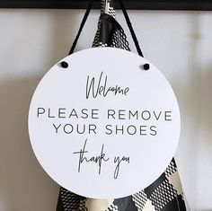 a sign that says welcome please remove your shoes thank you hanging on a door hanger