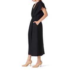 Black crepe (70% Viscose, 30% Wool). Hourglass. Short sleeves. V-neckline. Center back zipper closure. Partially lined. Pockets. 51.5" from shoulder to hemline. Imported. Modern V-neck Dress For Work, Sleek V-neck Midi Dress For Office, Black Midi Dress With Draped Sleeves For Work, Chic V-neck Dress With Notched Neckline For Office, Modern V-neck Midi Dress For Evening, Evening V-neck Midi Dress With Structured Shoulders, Modern V-neck Evening Midi Dress, Modern V-neck Cocktail Dress, Sleek V-neck Office Dress