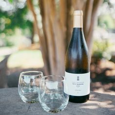 a bottle of wine and two glasses on a table