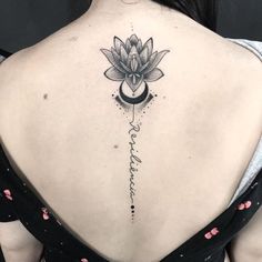 a woman's back with a lotus tattoo on it