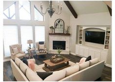 a large living room with high ceilings and white furniture