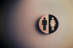 a sign on the wall that has a man and a woman in it for restrooms