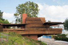 a wooden house sitting on the side of a hill