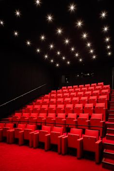 an empty auditorium with red seats and stars on the ceiling