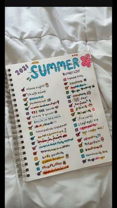 a notebook with the words summer written on it sitting on top of a white sheet