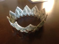 an origami ring made out of one hundred dollar bills sitting on a table