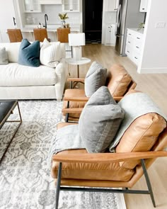 a living room filled with lots of furniture and pillows on top of a white rug