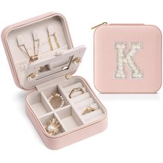 an open pink jewelry box with various items inside