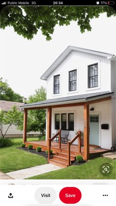 a small white house with a porch and stairs