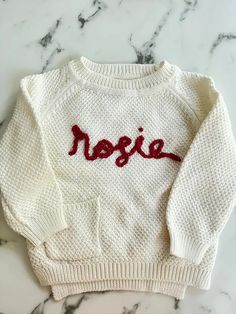 a white sweater with the word negie written on it, sitting on a marble surface