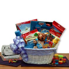 a teddy bear sitting in a basket filled with children's toys on a table