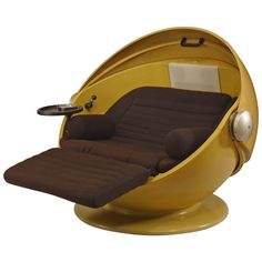 a yellow and brown chair sitting inside of a round shaped object with wheels on it