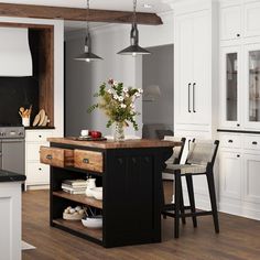 a kitchen with white cabinets and black counter tops, an island in the center is flanked by two bar stools