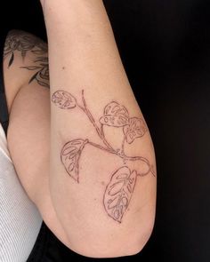 a woman's arm with tattoos on it and a plant growing out of it