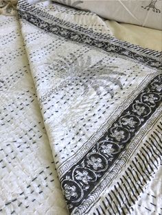 the black and white bedspread has an intricate design on it's edges